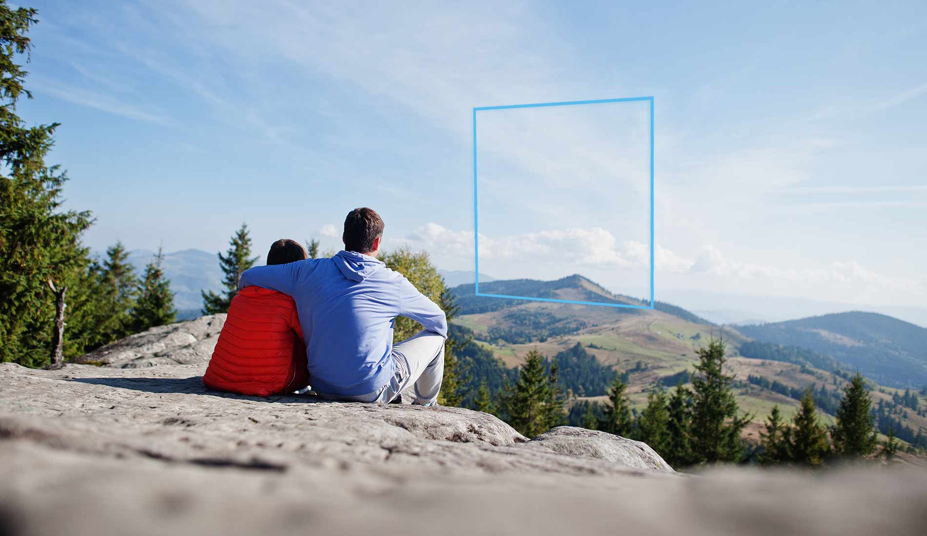 Vater und Sohn sitzen auf Felsen und blicken in die Ferne