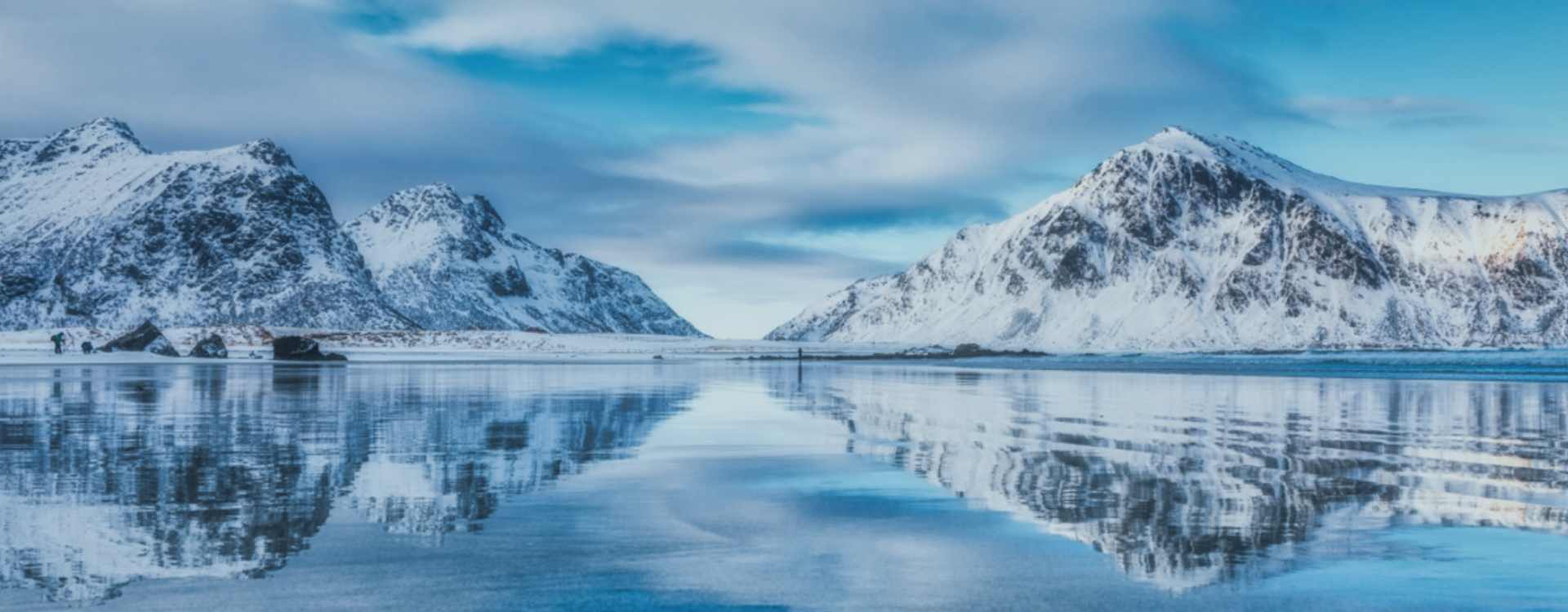 In the background of a large water surface, there are two icebergs on the left and another one on the right, with an ice area in the middle.